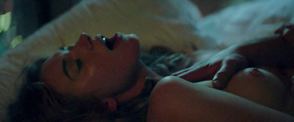 Here is Imogen Poots showing nude boobs, as she lays back on a bed and a gu...